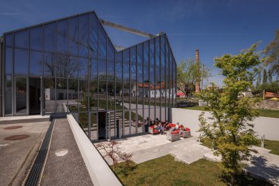 Espaço exterior moderno com um caminho de pedras rodeado por um jardim zen de areia e plantas ornamentais. A simplicidade do design e a presença de lanternas japonesas criam um ambiente sereno e equilibrado.