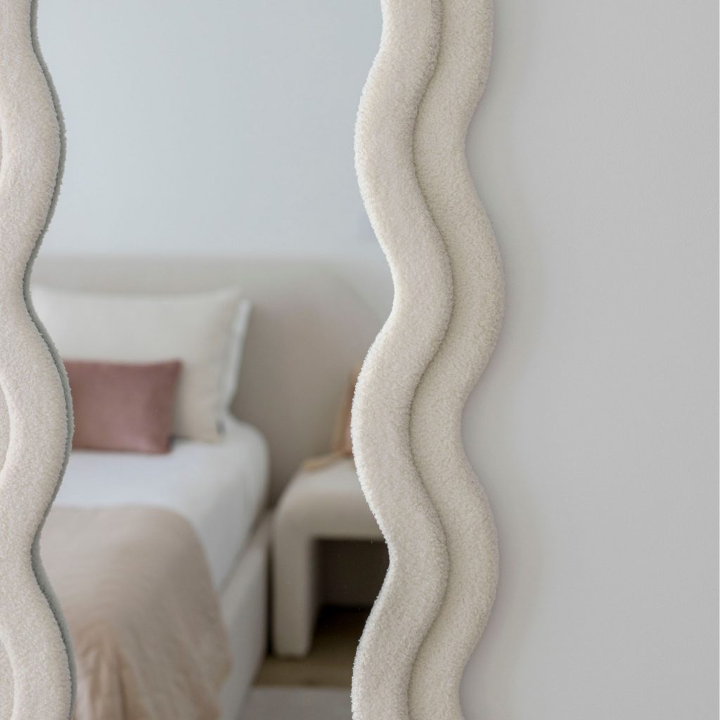 Tecido bouclé a contornar o espelho do quarto.