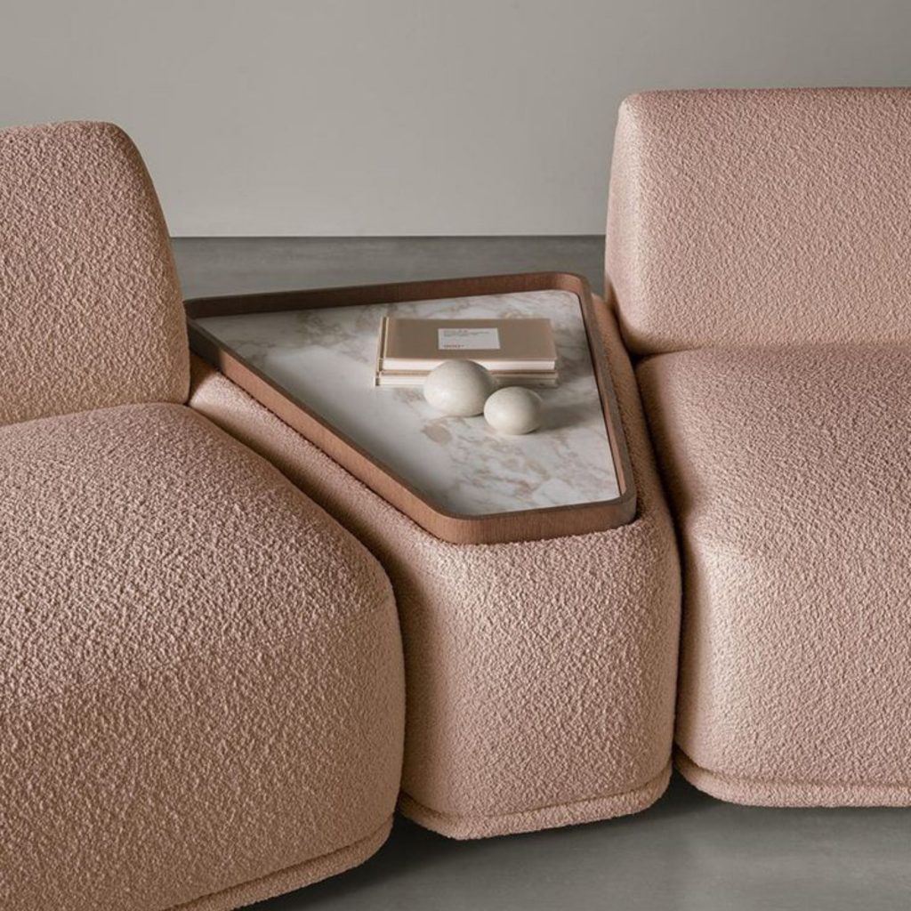 Sofá forrado em tecido bouclé, ideal para salas de estar modernas.