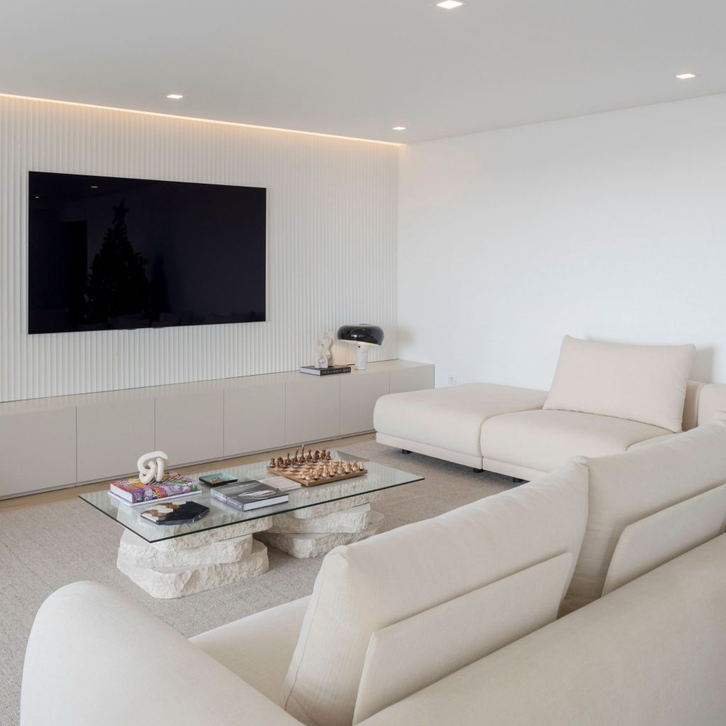 Uma sala de estar monocromática que assume o contemporâneo como o estilo do ambiente.