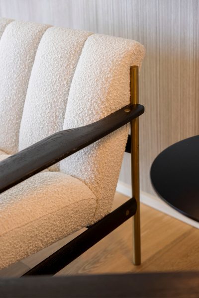 Detalhes de um cadeirção contemporâneo em tecido bouclé. Uma peça aconchegante e acolhedora.