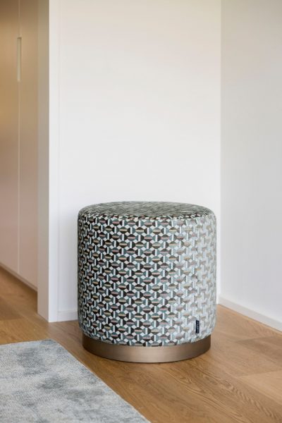 Pufe de design simples mas com um padrão vivo que confere dinamismo à decoração de quarto.