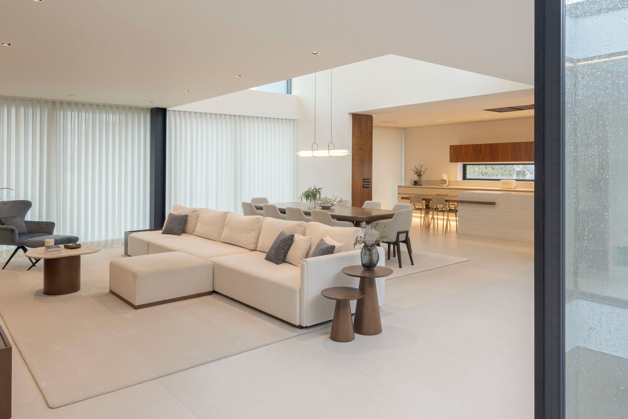 Open space contemporâneo com linhas minimalistas, criado através de um design de interiores que privilegia o bem-estar e reforça a saúde e bem-estar, com mobiliário neutro e luz natural abundante. O ambiente transmite serenidade e equilíbrio, demonstrando como o design de interiores pode apoiar a saúde mental e promover bem-estar, contribuindo para uma sensação contínua de saúde e bem-estar num espaço pensado para nutrir a saúde mental.