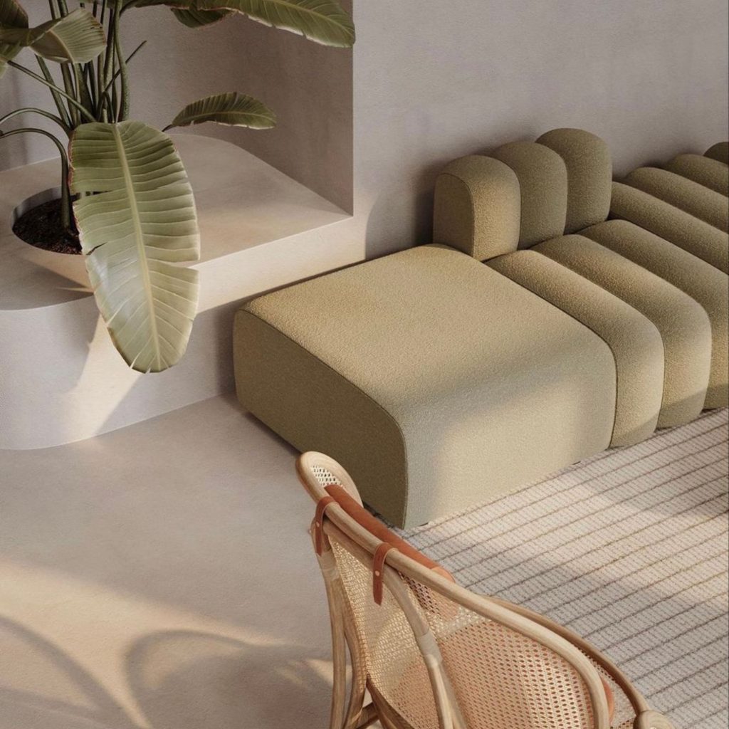 Espaço minimalista com sofá modular verde‑oliva e cadeira em rattan, onde detalhes subtis em cor pastel reforçam a suavidade do design de interiores. A presença de texturas naturais e volumes arredondados cria uma paleta de cores pastel discreta e contemporânea. O ambiente demonstra como o design de interiores pode integrar cor pastel de forma subtil, enquanto a paleta de cores pastel contribui para uma atmosfera calma e equilibrada.