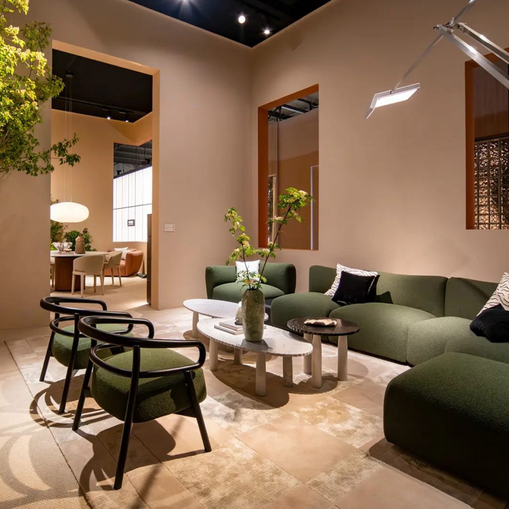 Sala contemporânea com sofá verde e zona de jantar integrada, refletindo influências do salone del mobile 2026 e das suas tendências. A composição elegante mostra como o salone del mobile 2026 continua a orientar o design de interiores, destacando tendências que valorizam materiais naturais e proporções equilibradas no design de interiores.