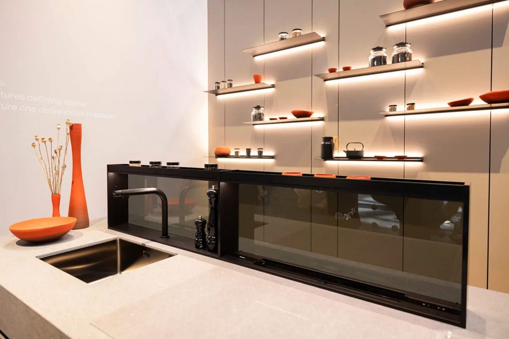 Cozinha moderna com linhas minimalistas e detalhes em preto e laranja, refletindo influências do salone del mobile 2026 e das suas tendências. A composição destaca como o salone del mobile 2026 continua a orientar o design de interiores, antecipando tendências que valorizam funcionalidade elegante e equilíbrio visual no design de interiores.