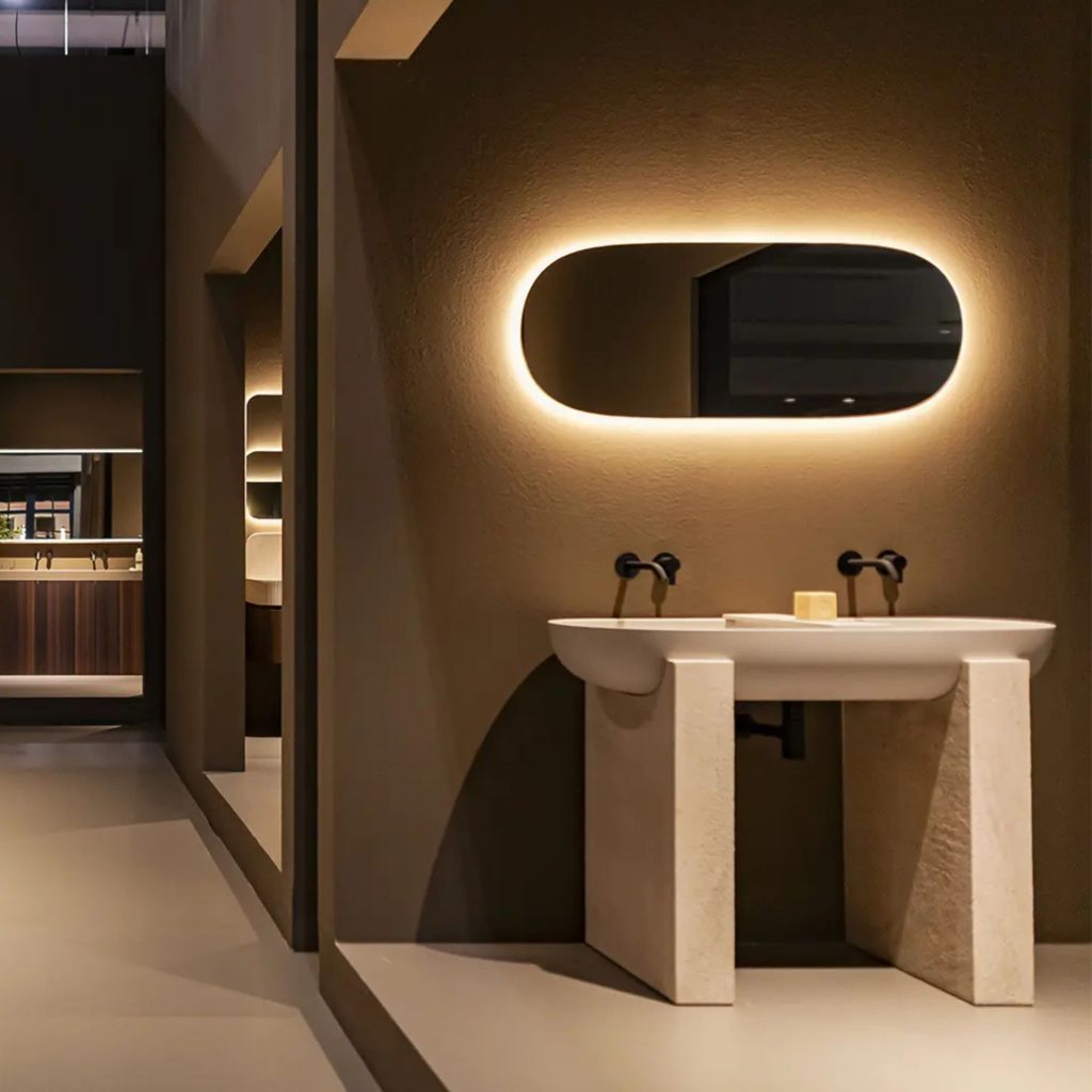 Casa de banho moderna com lavatório em pedra e iluminação suave, refletindo influências do salone del mobile 2026 e das suas tendências. A composição minimalista mostra como o salone del mobile 2026 continua a orientar o design de interiores, antecipando tendências que valorizam formas puras e materiais naturais no design de interiores