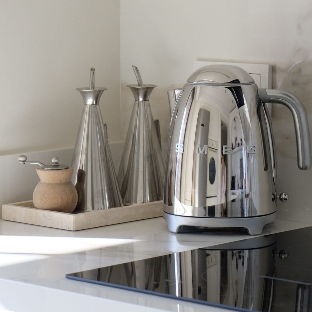 Conjunto de utensílios de cozinha agrupados por material — metal, madeira e cerâmica — para criar uma leitura visual limpa, alinhada com cozinhas modernas; a organização dos utensílios de cozinha por textura e brilho reforça a lógica das cozinhas modernas e a intenção do design de interiores, valorizando a coerência e a presença do design de interiores no espaço.