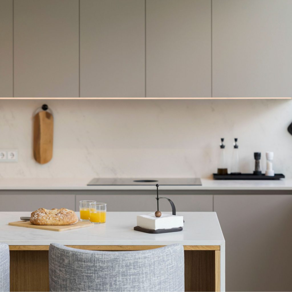 Cozinha moderna que utiliza utensílios de cozinha como elementos decorativos através de um tabuleiro organizado, criando uma leitura visual limpa alinhada com cozinhas modernas; a disposição cuidada dos utensílios de cozinha reforça a ordem das cozinhas modernas e evidencia a intenção do design de interiores, valorizando a presença subtil do design de interiores no espaço.