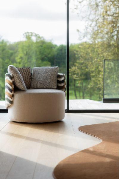 sala de estar moderna com cadeirão de formas arredondadas, criando uma sala de estar luminosa; o cadeirão destaca‑se como peça escultórica dentro da sala de estar moderna; atmosfera suave onde o cadeirão reforça a estética de sala de estar moderna integrada na sala de estar.