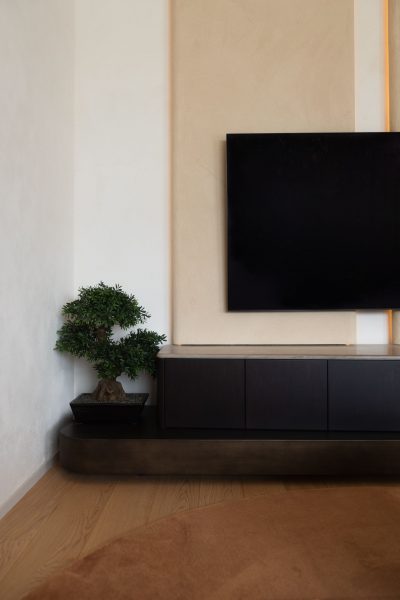 sala de estar moderna com composição minimalista onde a sala de estar se define por linhas limpas; detalhe do bonsai acrescenta textura à sala de estar moderna, mantendo a serenidade da sala de estar; equilíbrio visual que reforça a estética de sala de estar moderna num ambiente contemporâneo de sala de estar.