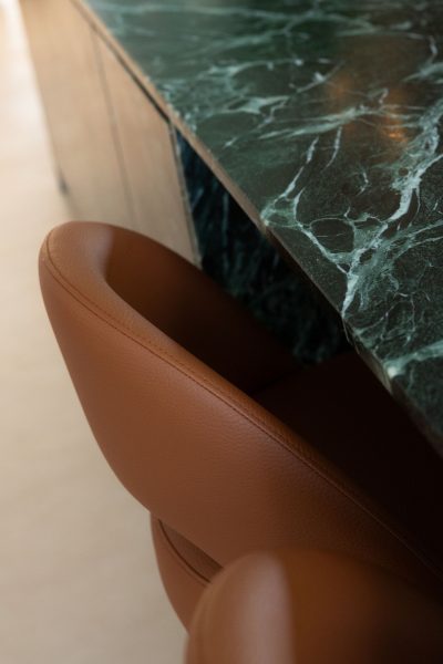 Cozinha moderna com ilha em destaque onde os bancos altos definem a zona de apoio da cozinha moderna. A presença dos bancos altos reforça a estética depurada da cozinha moderna com ilha. Uma composição elegante onde a textura dos materiais complementa os bancos altos e acentua a atmosfera de cozinha moderna e cozinha moderna com ilha.