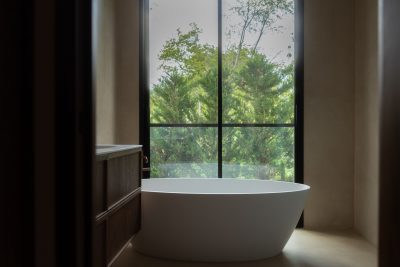 Decoração de quarto estendida ao ambiente adjacente, criando continuidade visual com a cama de casal. A luz natural reforça a serenidade da decoração de quarto. Composição minimalista onde a ligação entre espaços valoriza a presença conceptual da cama de casal, acentuando a coerência da decoração de quarto.