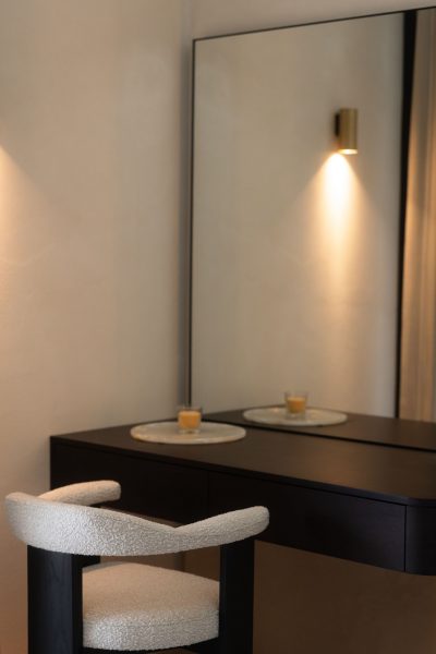 Decoração de quarto com toucador contemporâneo que dialoga com a zona da cama de casal. A iluminação quente reforça a suavidade da decoração de quarto. Composição equilibrada onde os materiais naturais e a luz difusa valorizam a cama de casal, consolidando a estética da decoração de quarto.