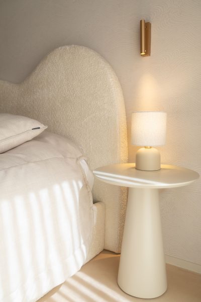 Mesa de cabeceira, candeeiro e aplique de parede em acabamento dourado num quarto de criança. A decoração evidencia a atenção ao detalhe, a decoração acrescenta sofisticação discreta e a decoração reforça a identidade do espaço. O design de interiores trabalha a iluminação em diferentes camadas, o design de interiores privilegia o conforto e o design de interiores cria profundidade visual. Este quarto de criança beneficia de soluções cuidadosamente selecionadas, tornando o quarto de criança funcional, o quarto de criança acolhedor e o quarto de criança harmonioso.