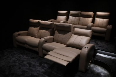 Conjunto de poltronas reclináveis em pele com apoio para os pés integrado num confortável cinema em casa. O projeto de design de interiores privilegia o bem-estar dos utilizadores, o projeto de design de interiores combina materiais nobres com tecnologia e o projeto de design de interiores reforça a sensação de exclusividade. Este cinema em casa oferece uma experiência totalmente imersiva, consolidando o papel do cinema em casa como uma das áreas mais marcantes da residência.