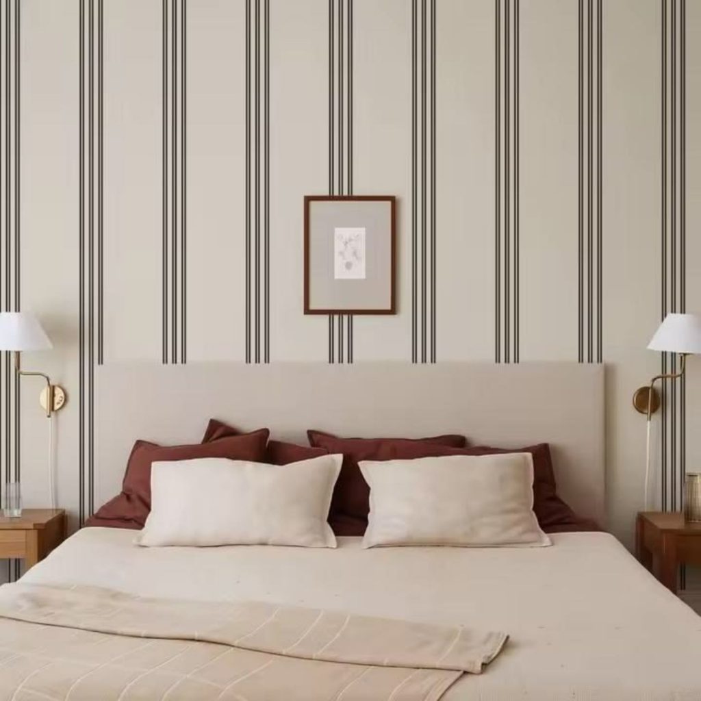 Quarto marcado por riscas verticais no revestimento da parede, reforçando a presença de riscas verticais como elemento estruturante e ampliando a leitura ordenada das riscas verticais na composição; o espaço revela um design de interiores equilibrado, onde o design de interiores privilegia simetria e luz e onde o design de interiores integra a tradição gráfica das riscas; os padrões evocam tecidos às riscas que evoluíram do imaginário marítimo para a sofisticação doméstica, remetendo para tecidos às riscas como linguagem duradoura e reforçando a presença histórica dos tecidos às riscas; a parede assume a estética de papel de parede riscas, evocando papel de parede riscas como tema central e ampliando a narrativa visual dos papel de parede riscas no ambiente.