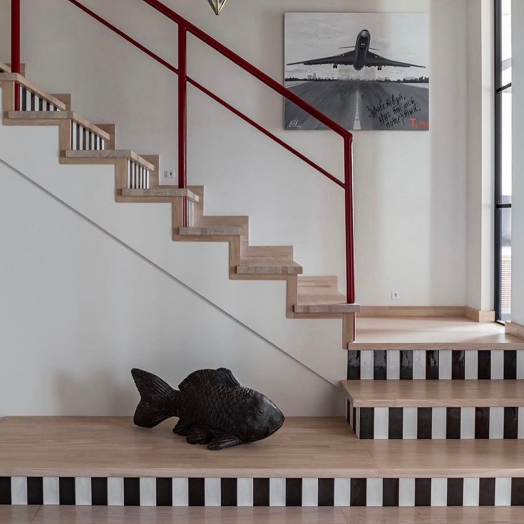 Escada marcada por riscas verticais nos risers, ampliando a presença de riscas verticais como gesto gráfico e reforçando a leitura ordenada das riscas verticais na transição entre pisos; o espaço revela um design de interiores ousado, onde o design de interiores privilegia contraste e ritmo e onde o design de interiores integra elementos escultóricos e pictóricos; os padrões evocam tecidos às riscas que atravessaram moda, mar e interiores, remetendo para tecidos às riscas como símbolo de ordem e frescura e reforçando a narrativa histórica dos tecidos às riscas; a estética aproxima‑se da lógica de papel de parede riscas, sugerindo papel de parede riscas como inspiração gráfica e ampliando a leitura de papel de parede riscas na construção visual da escada.