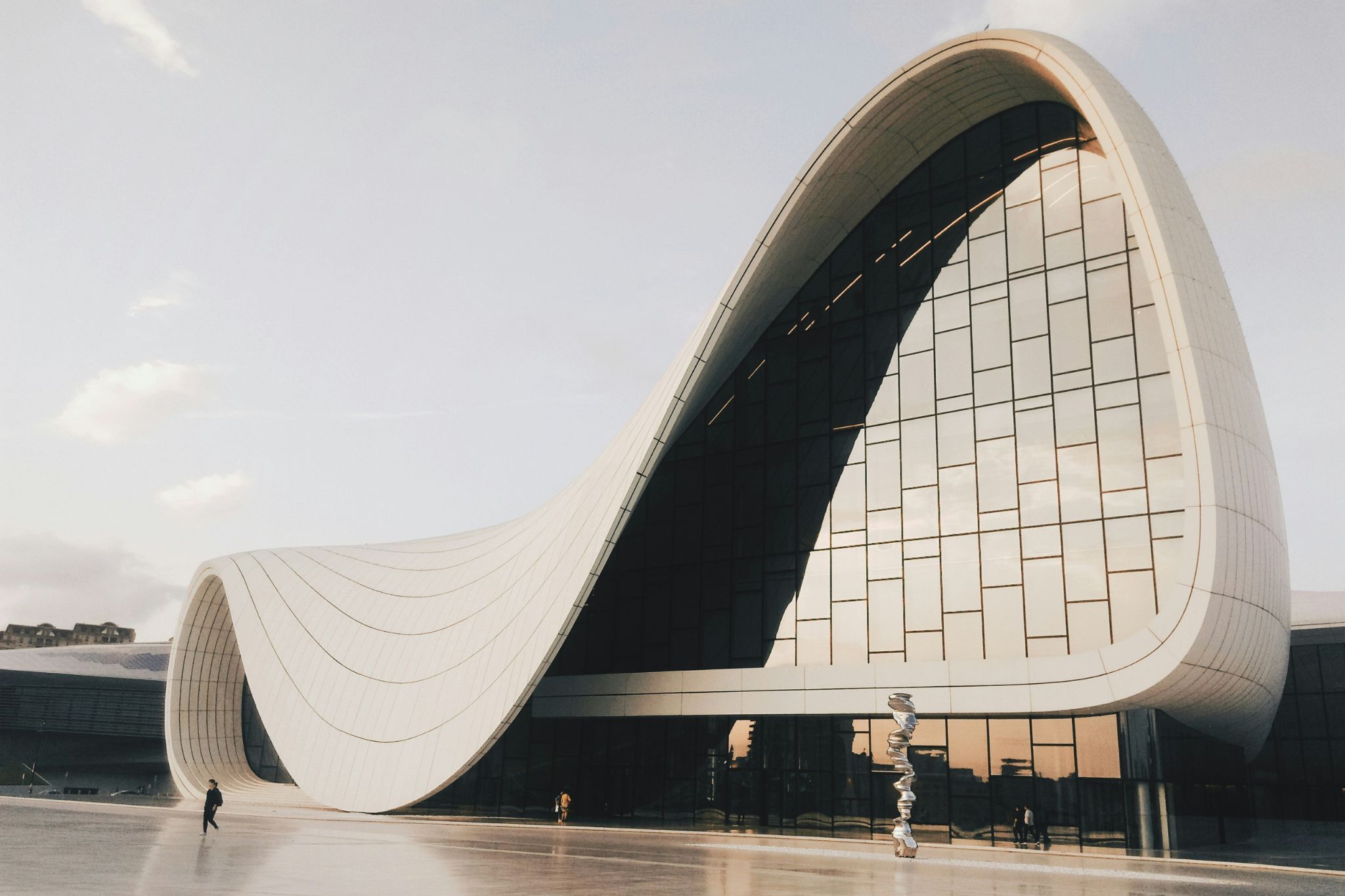 Edifício contemporâneo onde a arquitetura orgânica se expressa em curvas fluidas que redefinem a relação entre a casa e o espaço público, criando um diálogo subtil com princípios de design biofílico que reforçam o bem‑estar. A fachada envidraçada evidencia um design de interiores pensado para prolongar a arquitetura orgânica para o exterior, ampliando a sensação de bem‑estar e aproximando a casa de uma leitura sensorial inspirada pelo design biofílico. As formas escultóricas revelam uma arquitetura orgânica que transforma o edifício numa casa conceptual, sustentada por um design de interiores que privilegia o bem‑estar e pela presença contínua do design biofílico.