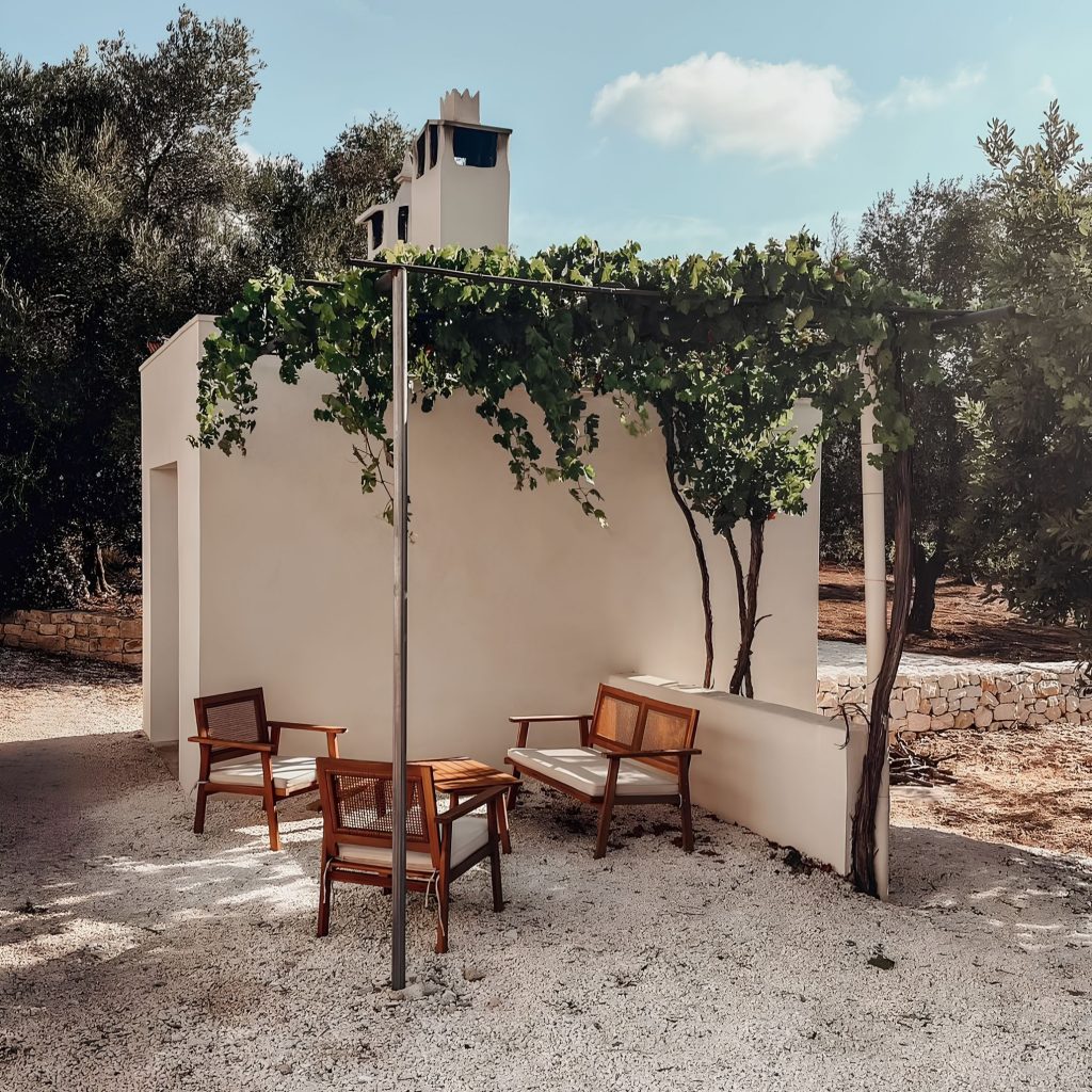 Espaço exterior que traduz a serenidade de uma casa algarvia, integrado na atmosfera das casas de férias no algarve e na identidade das Casas do algarve, refletindo o carácter das Casas no algarve e sugerindo ambientes de decoração de verão que dialogam com princípios de design de interiores; As cadeiras em madeira reforçam a presença de uma casa algarvia, articulando elementos das casas de férias no algarve com referências às Casas do algarve, criando continuidade com o estilo das Casas no algarve e com a vibração de decoração de verão aplicada ao design de interiores; A pérgula com videira intensifica a atmosfera de uma casa algarvia, evocando o espírito das casas de férias no algarve e a tradição das Casas do algarve, alinhando-se com o conforto das Casas no algarve e com a estética descontraída da decoração de verão que inspira o design de interiores; A pequena mesa reforça novamente a imagem de uma casa algarvia, remetendo para o ambiente das casas de férias no algarve e para os materiais das Casas do algarve, criando paralelos com o carácter das Casas no algarve e com os detalhes de decoração de verão que moldam o design de interiores; O enquadramento final celebra a autenticidade de uma casa algarvia, a atmosfera das casas de férias no algarve, a estética das Casas do algarve, o estilo das Casas no algarve, a vibração da decoração de verão e a inspiração contínua do design de interiores.