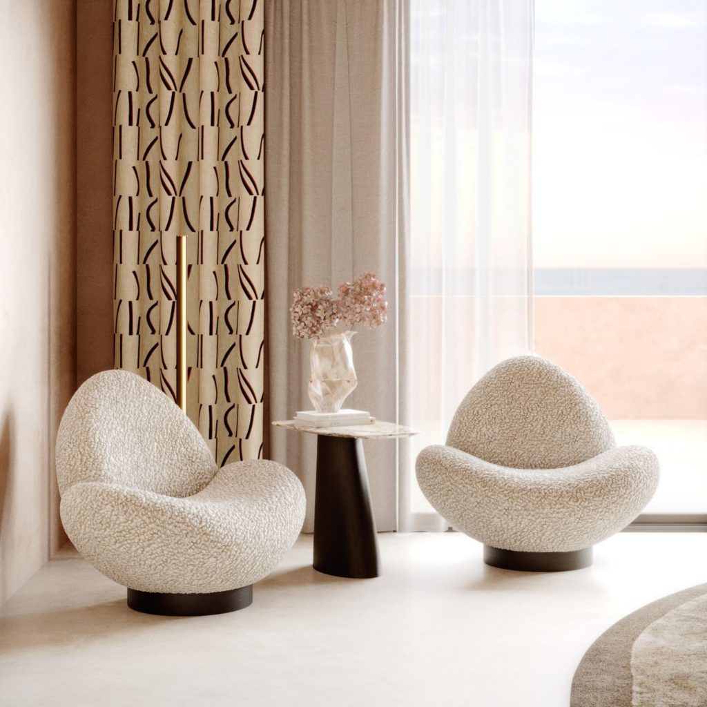 Recanto de leitura para biblioteca em casa com elegante cadeirão duplo em tecido boucle, mesa de apoio com flores e peças de decoração sofisticada, complementando um ambiente planeado para receber estante e estantes para livros com assinatura de design de interiores.